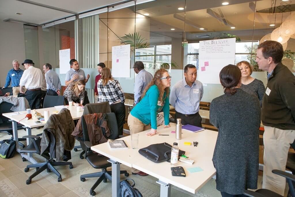 A room of stakeholders with posters describing