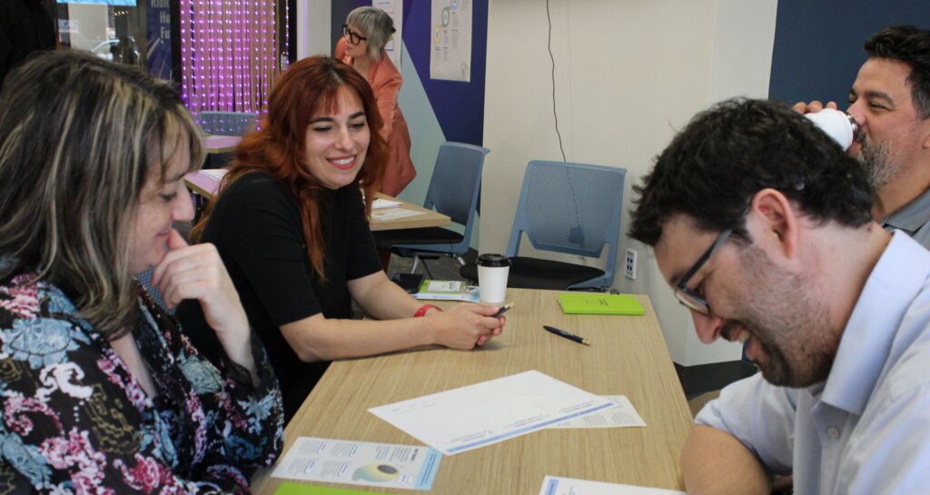 group of people around a table smiling and working on worksheets