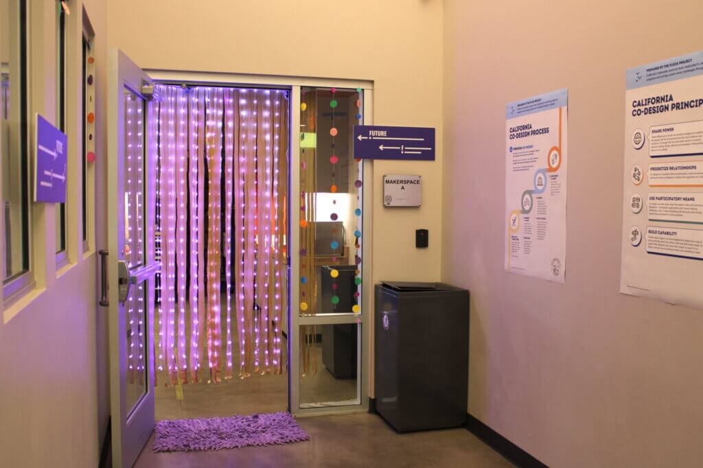 picture of a portal with lights - purple and yellow streamers hanging down from a door