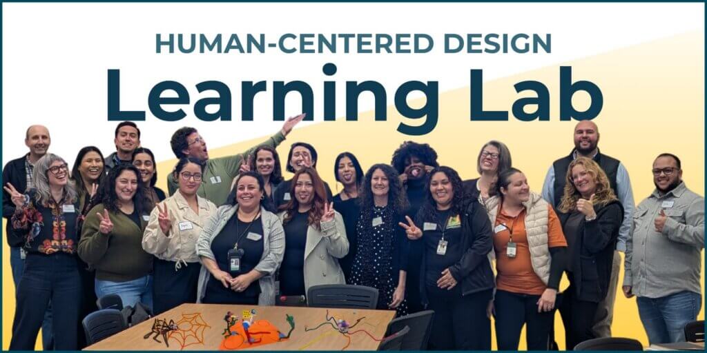 21 people in a group photo at the end of the February Showcase. It includes members of the 2025-2026 HCD Learning Lab, session attendees from across the workforce ecosystem, and CivicMakers facilitators. People are making silly faces or holding up peace signs. In front of them is a table featuring some of the pipe-cleaner prototypes that they built during the session.